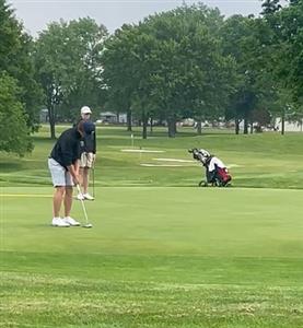 Lucas Lafferty holding golf club appearing to be about to ready himself to putt, standing at a distance  